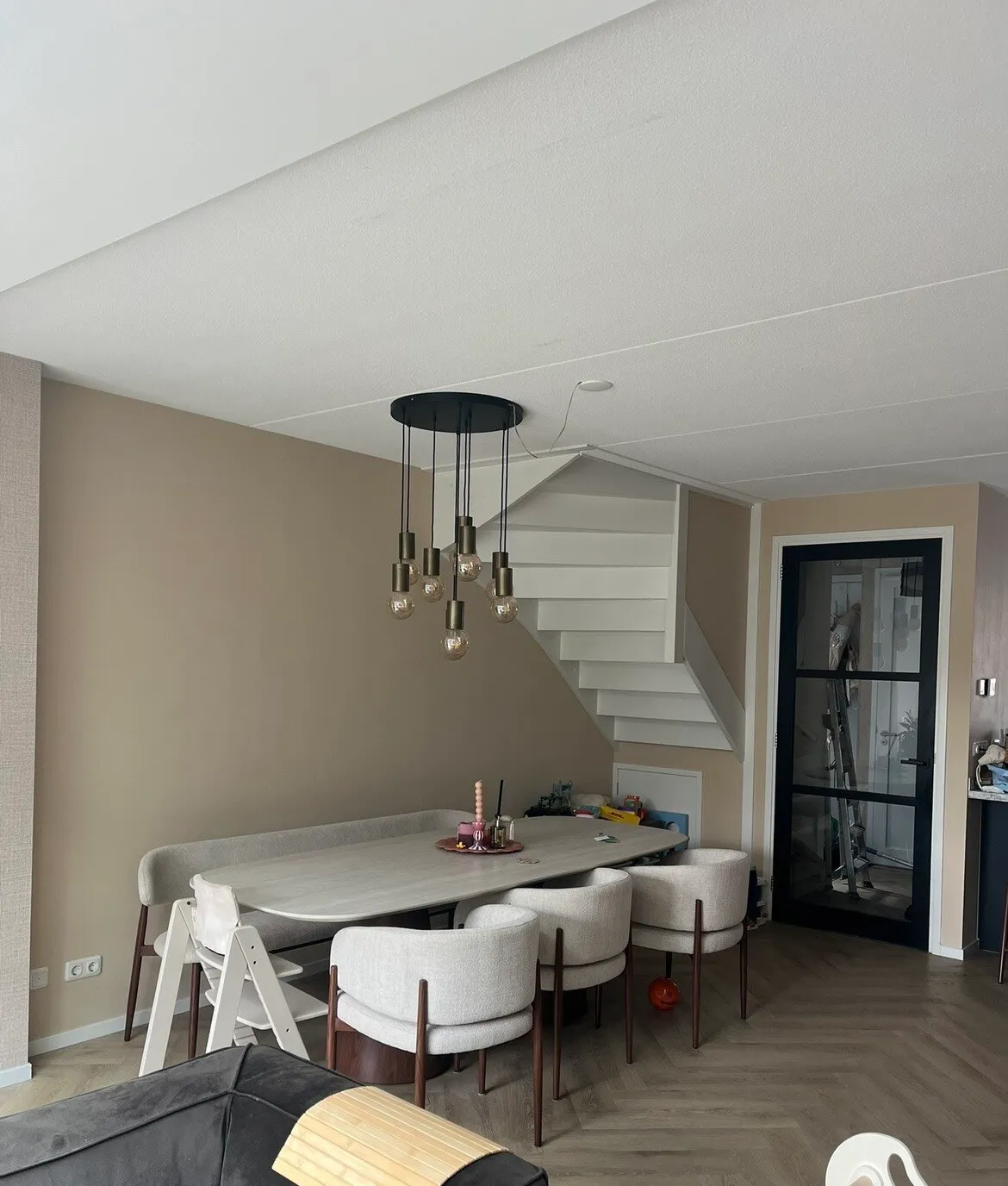 Trapgat/woonkamer met zachte taupe muur en hanglamp